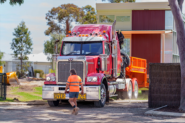 Rapid Modular WA building module being transported on a flatbed truck to site